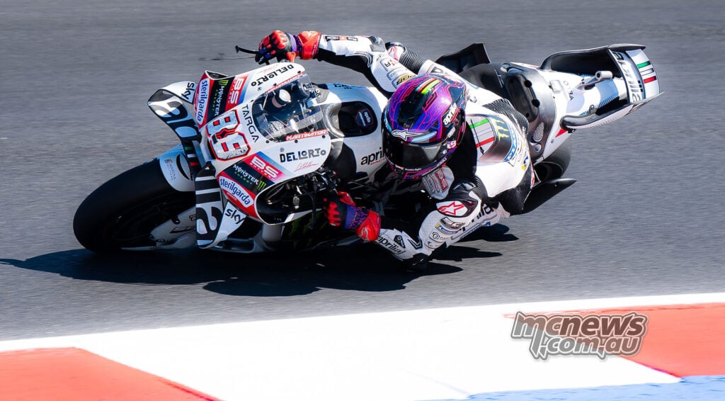 Jorge Martin leans his number 89 Aprilia into a corner, with his knee close to the asphalt.