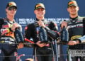 Collin Veijer, Manuel Gonzalez and Barry Baltus stand together holding bottles on the Misano Moto2 podium.