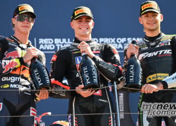 Collin Veijer, Manuel Gonzalez and Barry Baltus stand together holding bottles on the Misano Moto2 podium.
