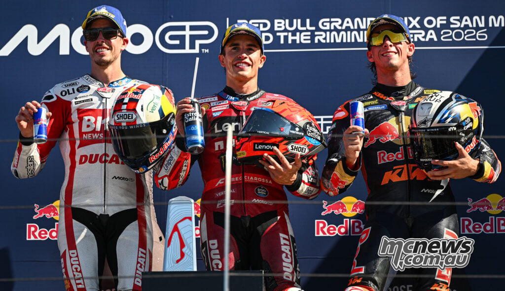 Alex Marquez, Marc Marquez and Pedro Acosta pose with their helmets on the Misano podium.
