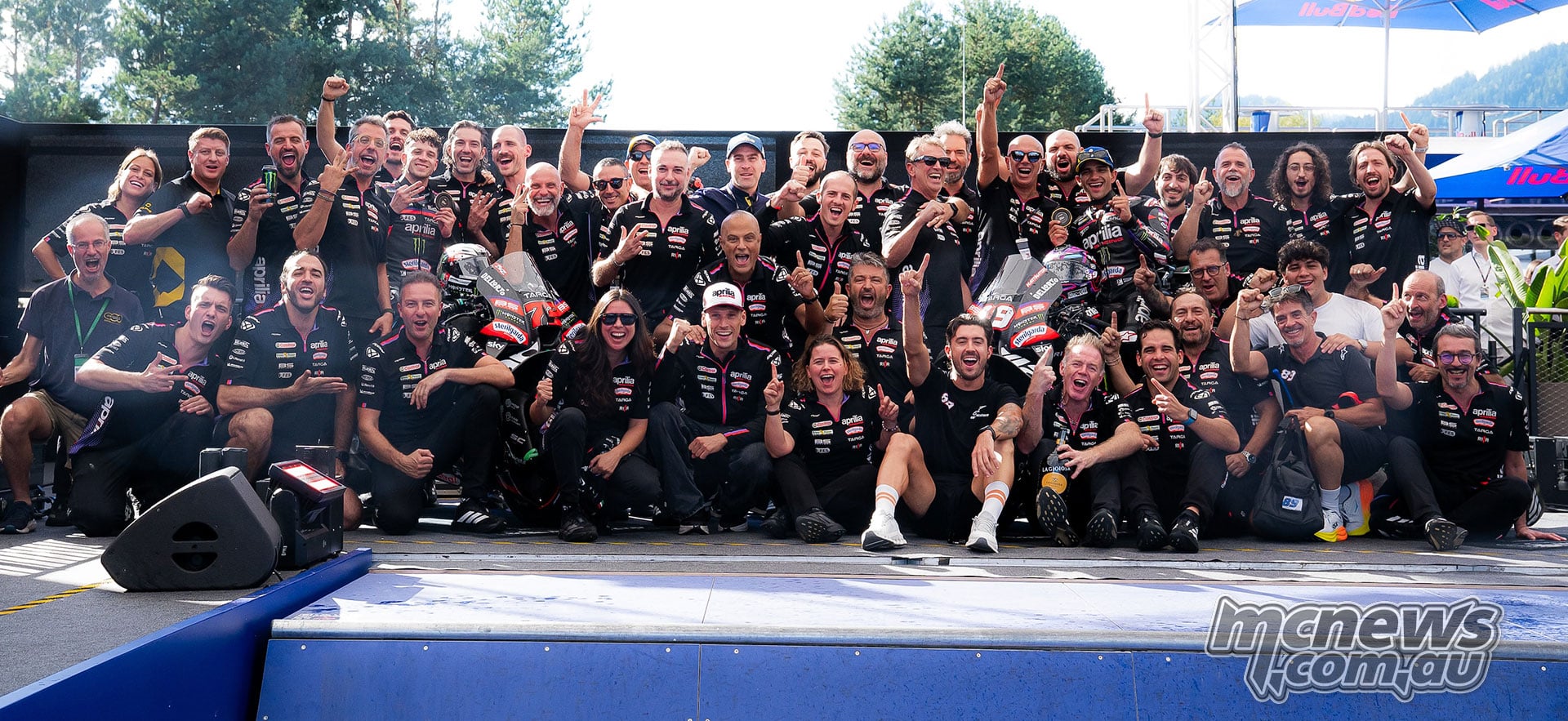 Aprilia riders and team members pose together celebrating their Austrian Sprint results.