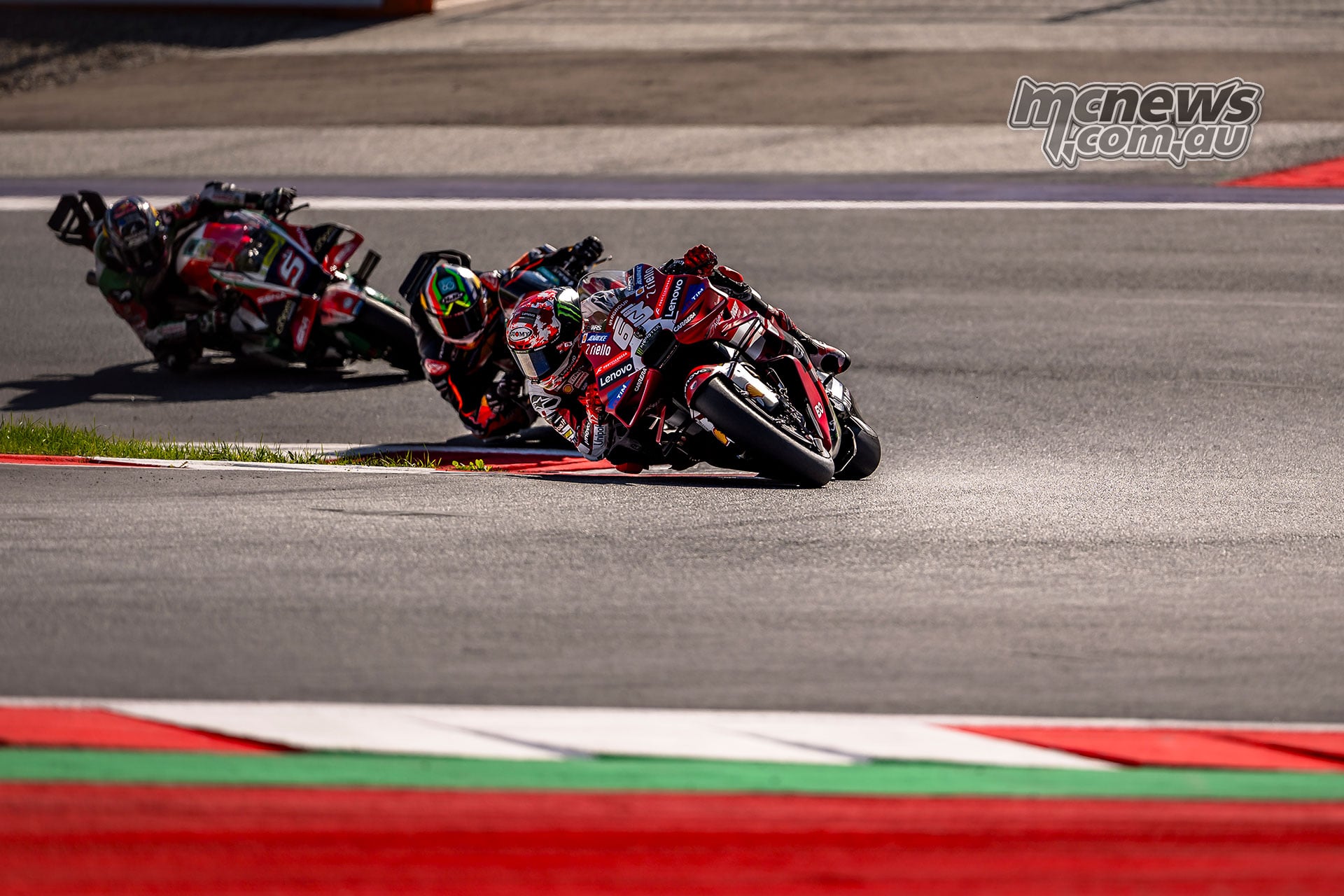 Francesco Bagnaia corners on his factory Ducati with another rider following behind.