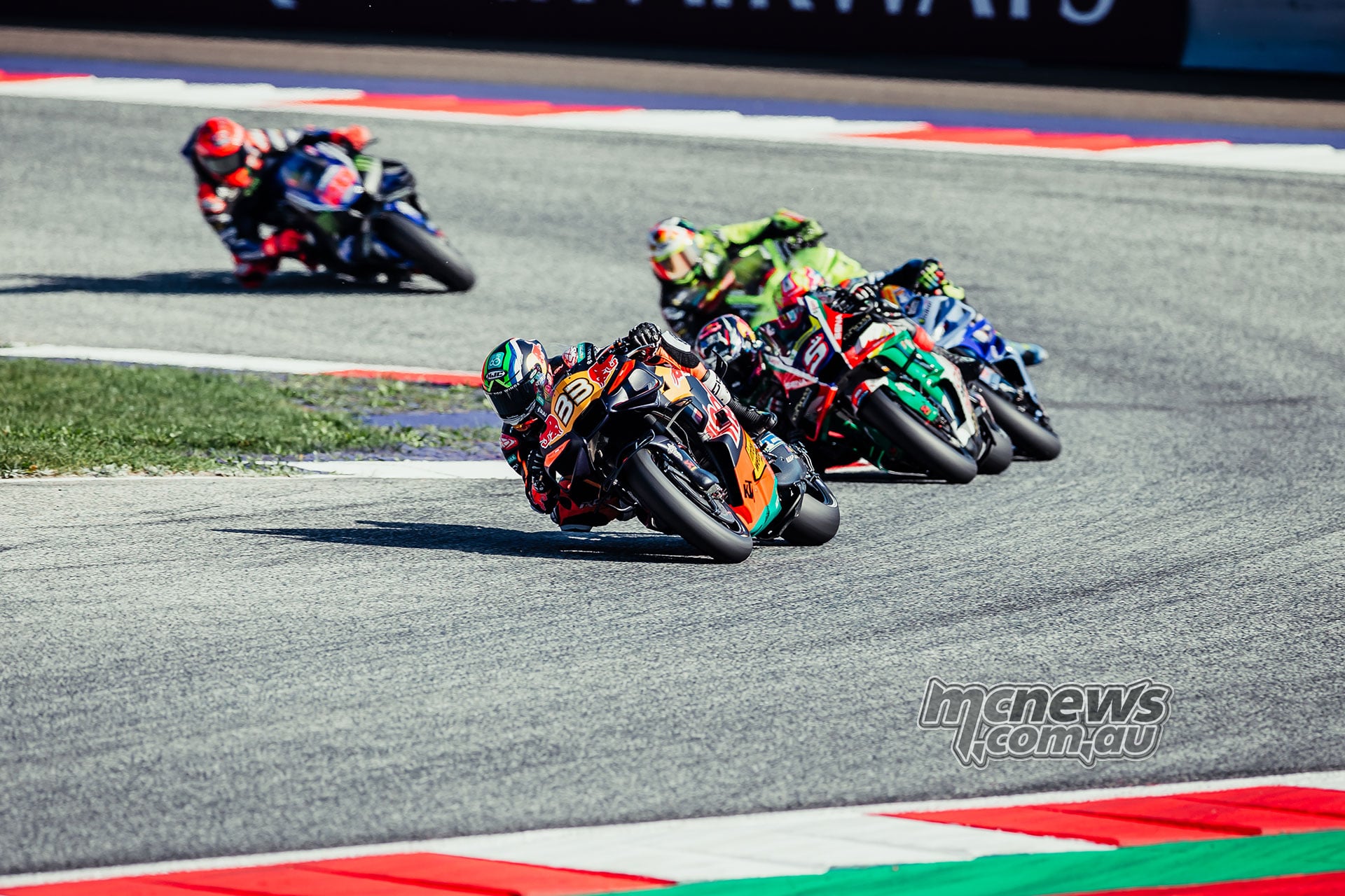 Brad Binder leads Johann Zarco and a group of riders through a Red Bull Ring corner.