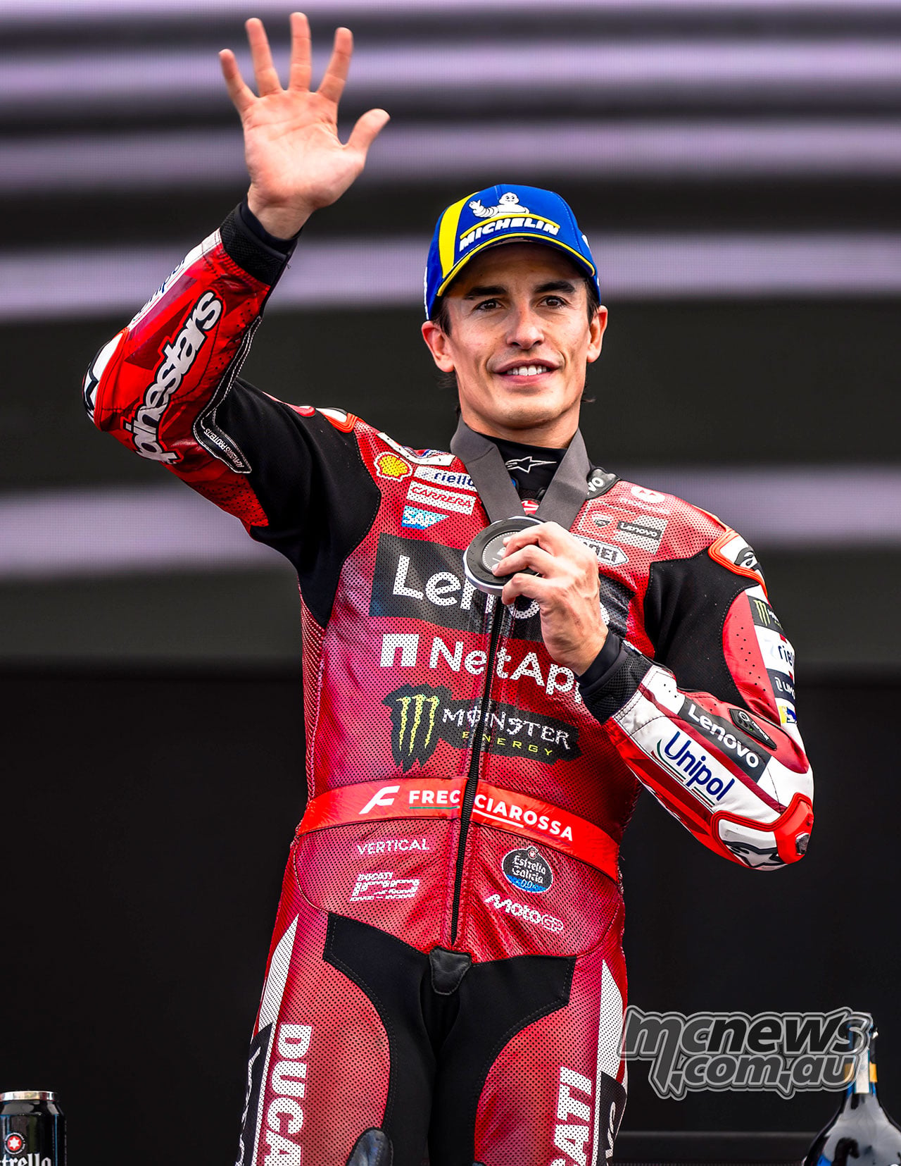 Marc Marquez waves while holding his silver Sprint medal on the Austrian podium.