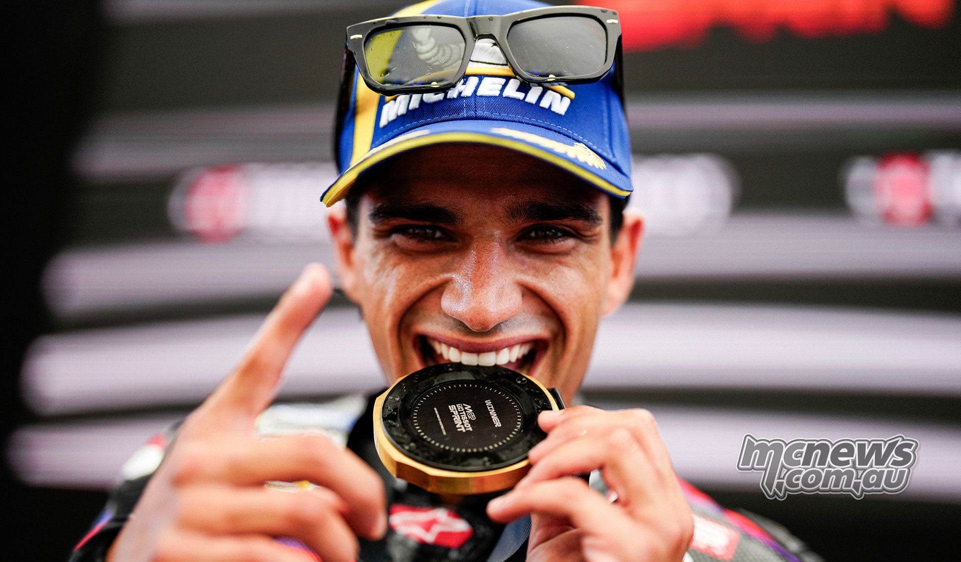Jorge Martin bites his gold Sprint medal and raises one finger at the Red Bull Ring.
