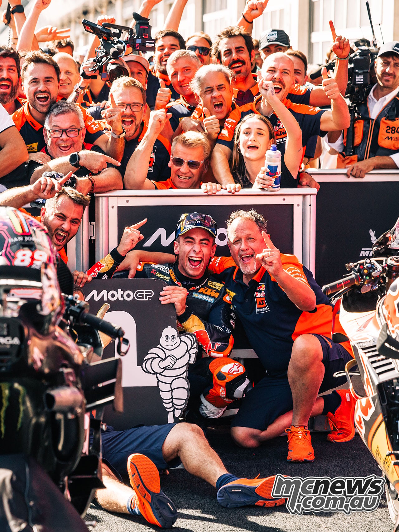Pedro Acosta embraces Paul Trevathan in parc ferme beside the P1 pit board.