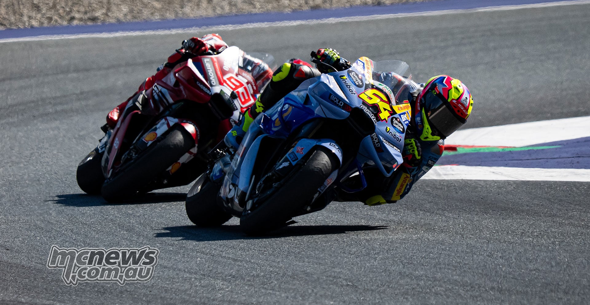 Fermin Aldeguer leads Marc Marquez as the Ducati riders lean through a corner.