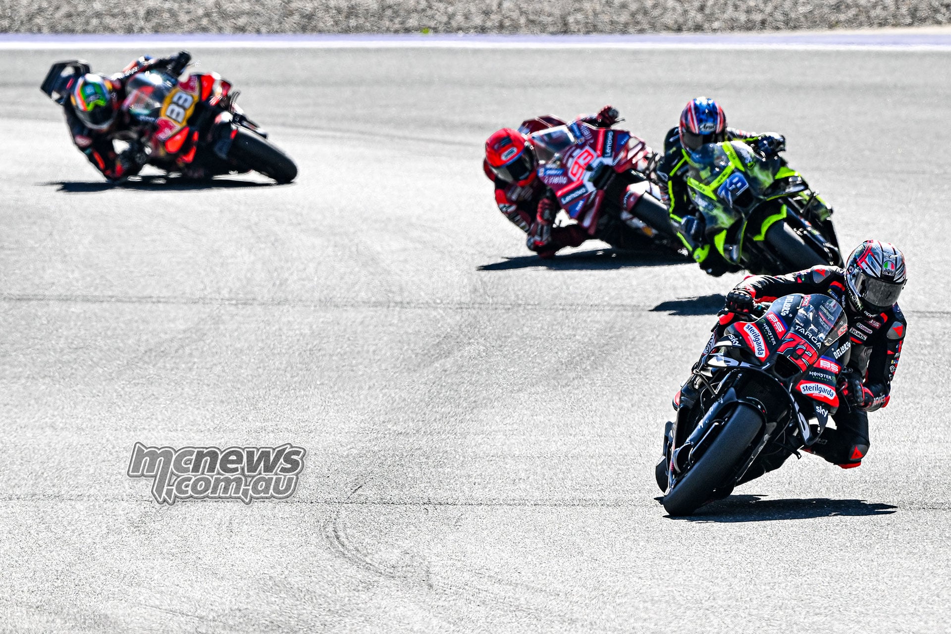 Marco Bezzecchi leads Ai Ogura, Marc Marquez and Brad Binder through a corner.