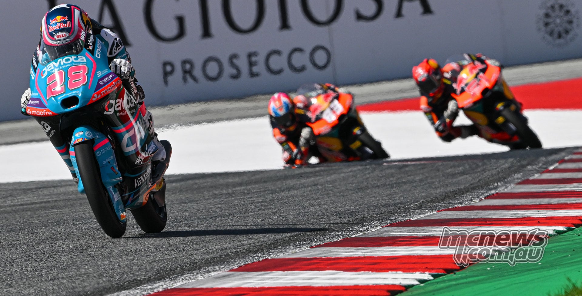 Maximo Quiles leads on his turquoise number 28 motorcycle, with the two Red Bull KTM Ajo riders behind.
