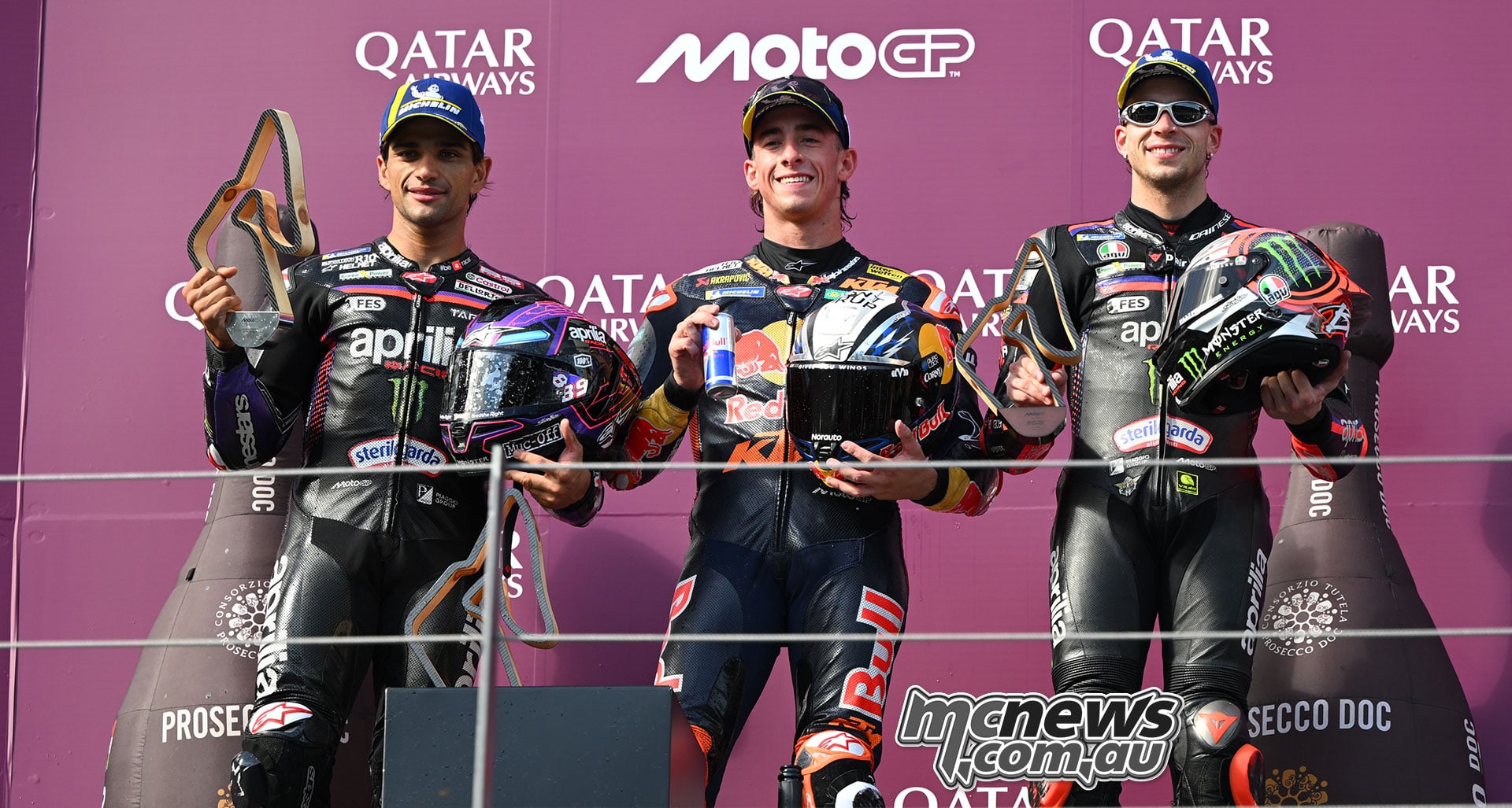 Jorge Martin, Pedro Acosta and Marco Bezzecchi display their trophies on the Austrian Grand Prix podium.
