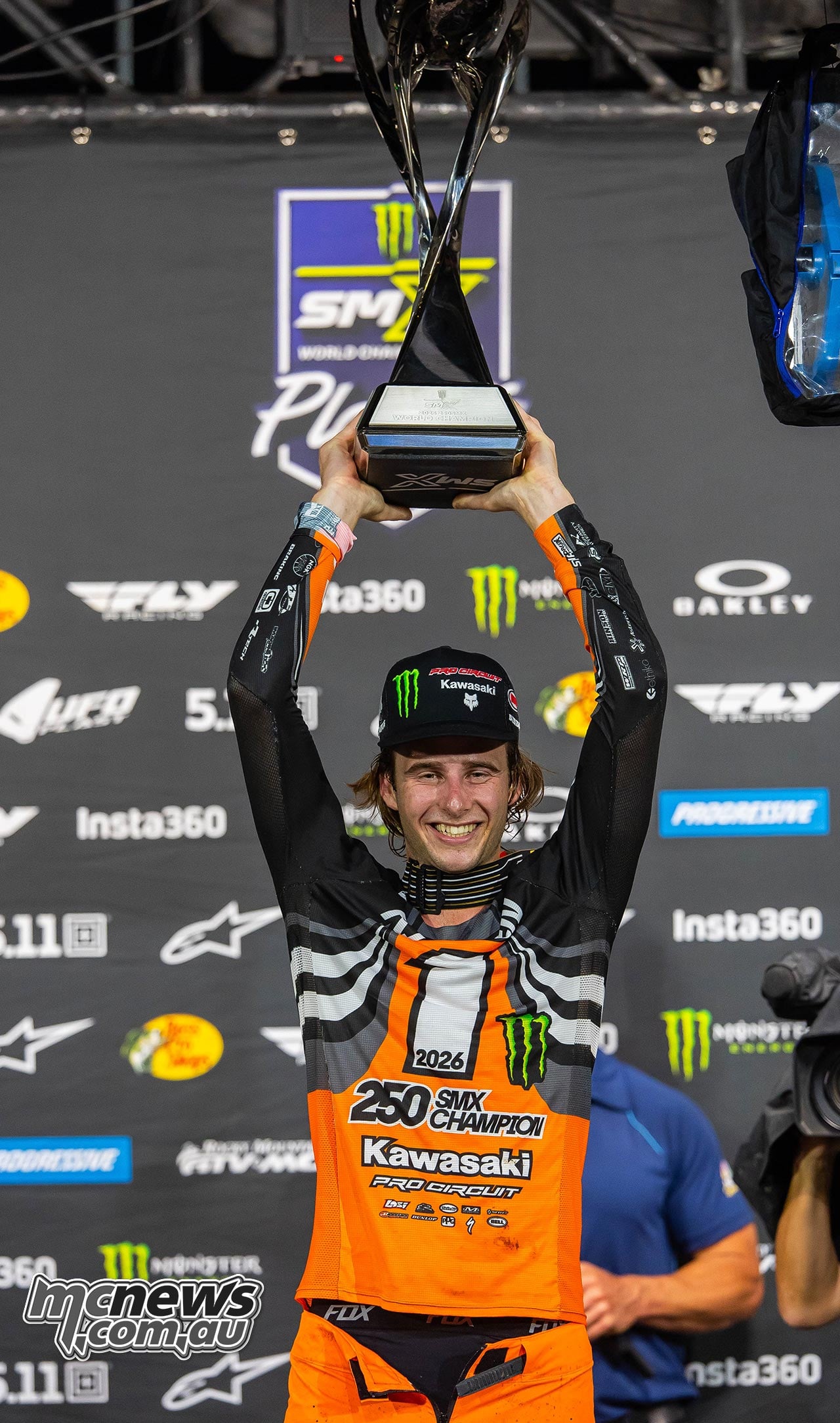 Levi Kitchen raises the 250 SMX championship trophy above his head.
