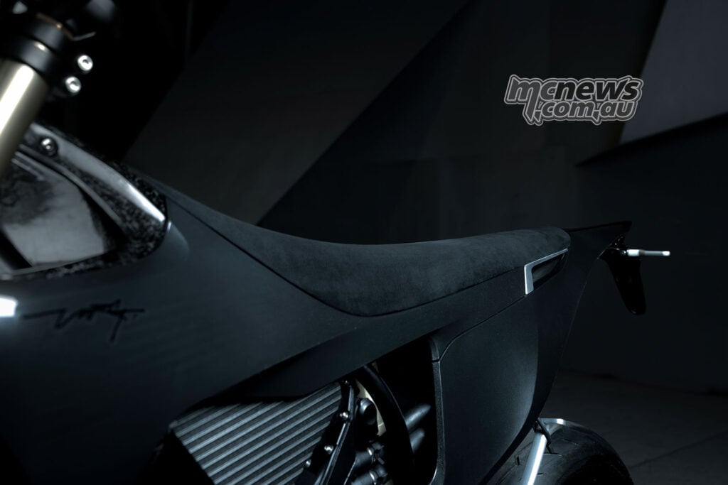Side view of the Stark VARG SM Sköll’s black seat and bodywork, with a fork leg in the foreground.