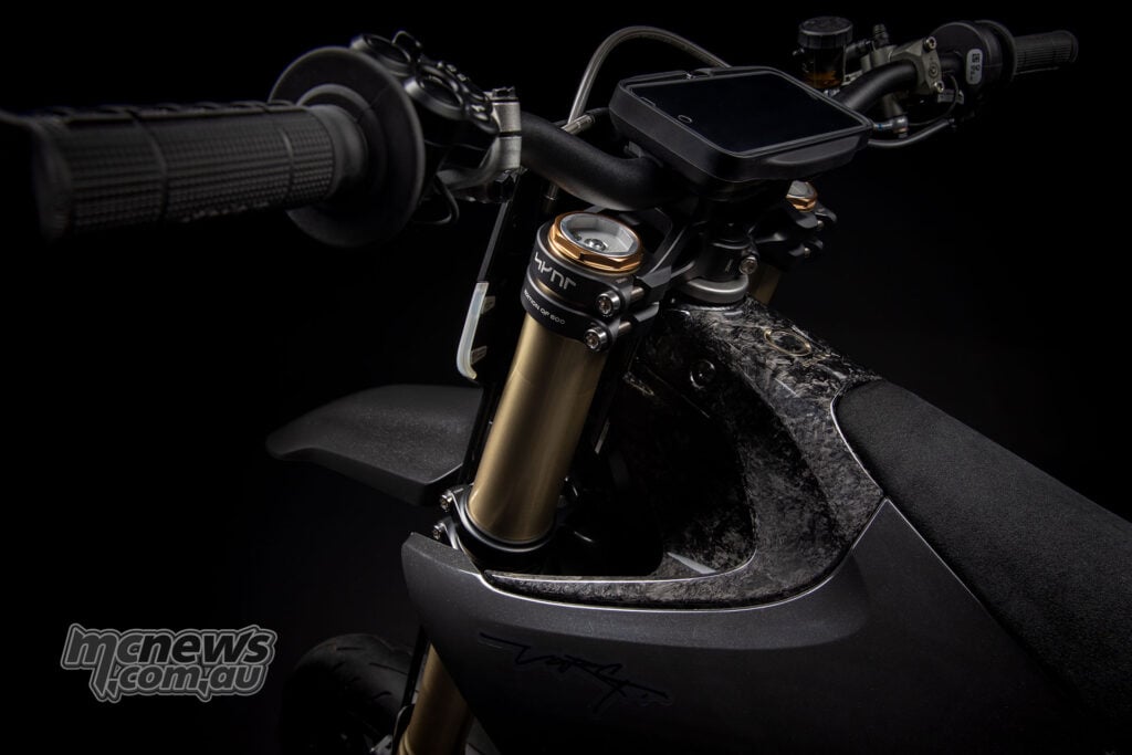 Angled view of the Stark VARG SM Sköll’s handlebar, display, gold fork tops and mottled front body panel.
