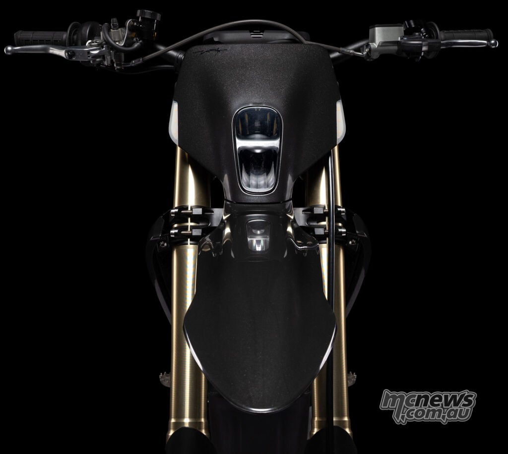 Head-on view of the Stark VARG SM Sköll’s vertically stacked headlight, handlebar, front mudguard and gold forks.