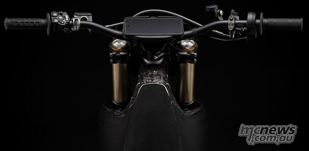 Symmetrical rider’s view of the Stark VARG SM Sköll’s handlebar, central display and black seat against a dark background.