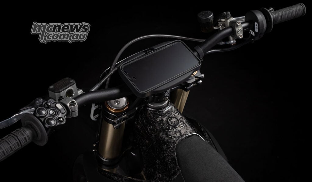 Oblique overhead view of the Stark VARG SM Sköll’s display, left switch cluster, handlebar and fork tops.