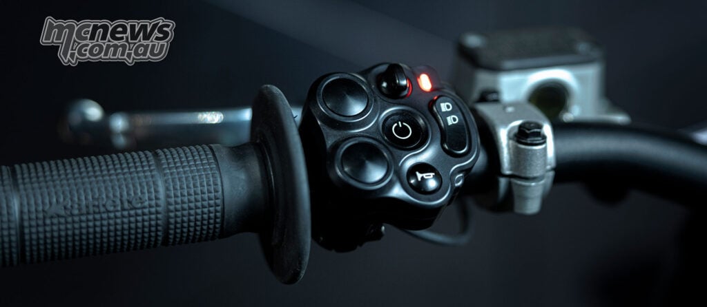 Close-up of the Stark VARG SM Sköll’s left handlebar switch cluster, grip and illuminated red indicator.
