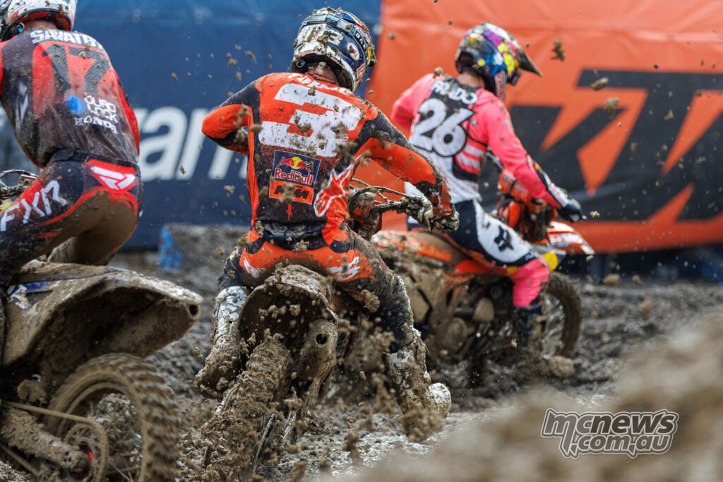 Rear view of Joey Savatgy, Eli Tomac and Jorge Prado riding close together through deep mud at Columbus.