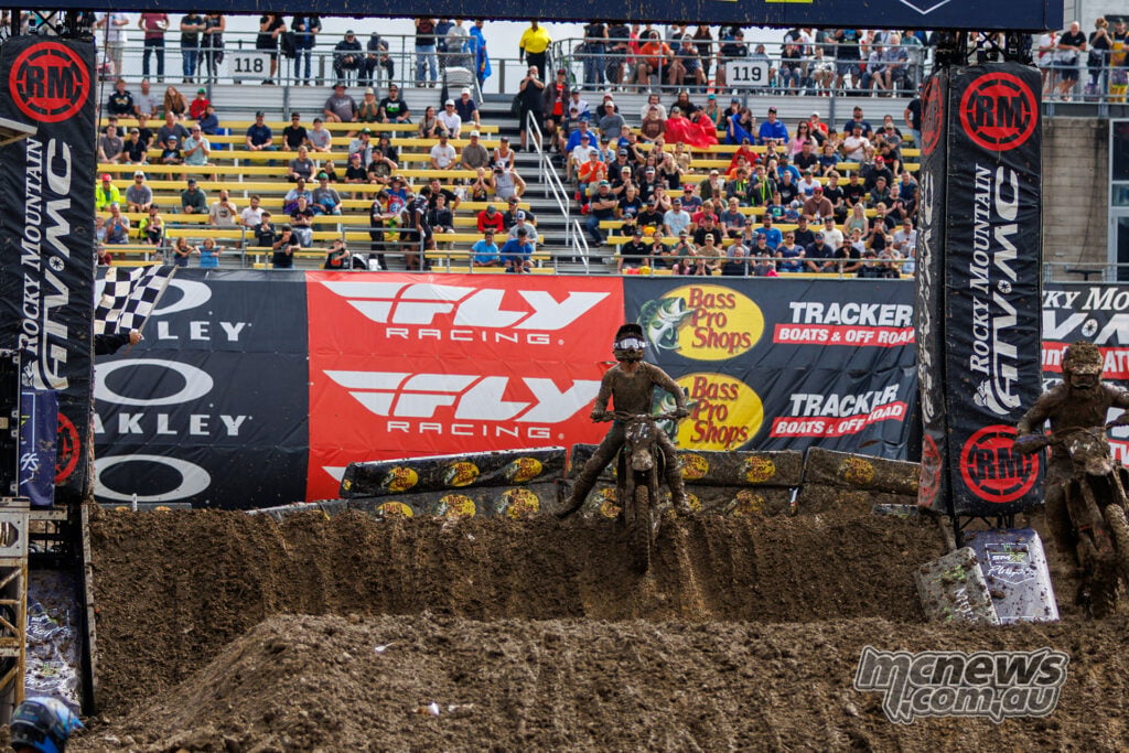 Haiden Deegan rides beneath the finish gantry and chequered flag to win the muddy opening 450SMX moto at Columbus.