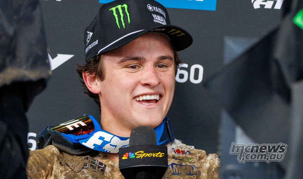 Haiden Deegan smiles during his post-race interview, wearing a Yamaha cap and mud-covered race gear.