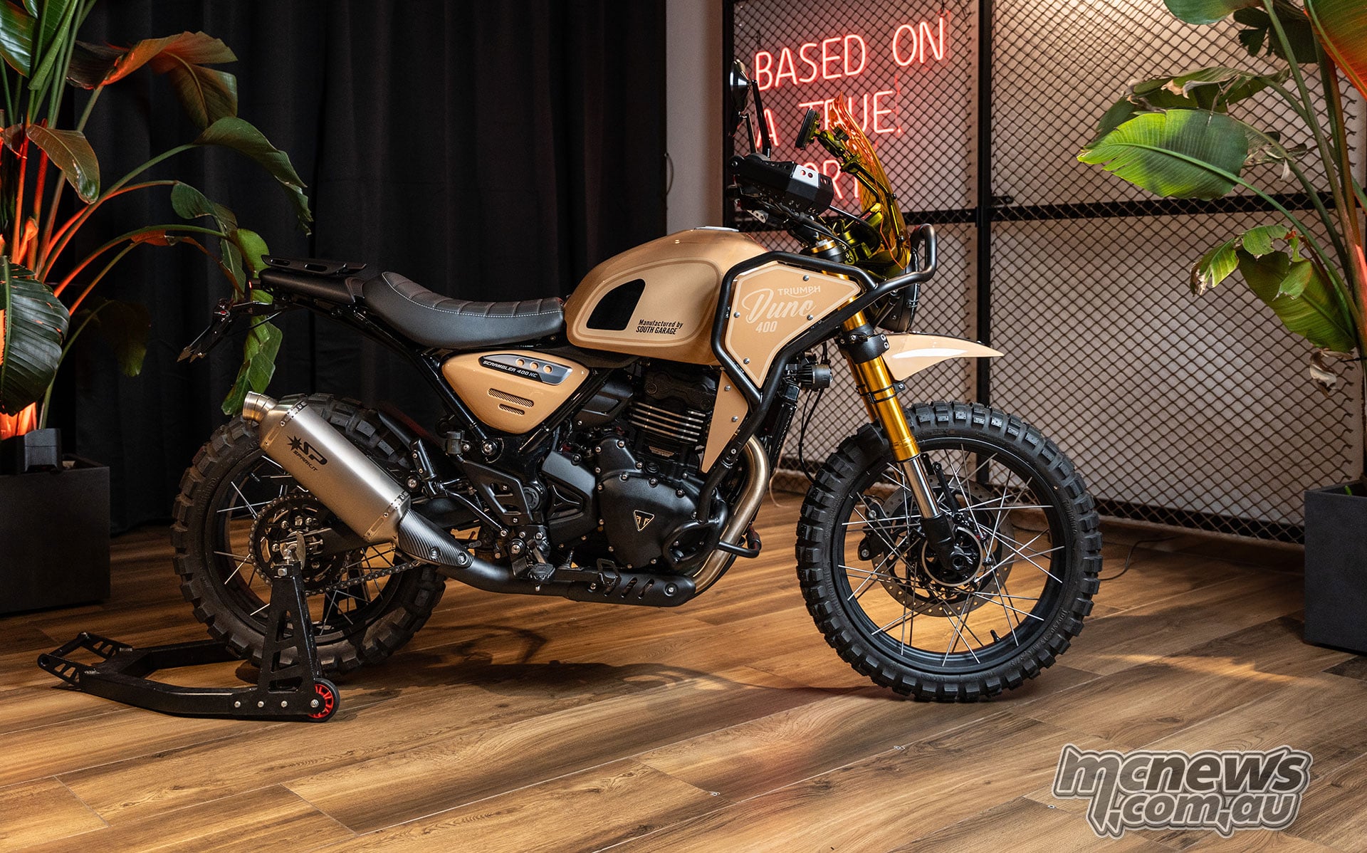 Sand-coloured South Garage Dune 400 custom with rally-style bodywork, a windscreen, crash bars and spoked wheels.