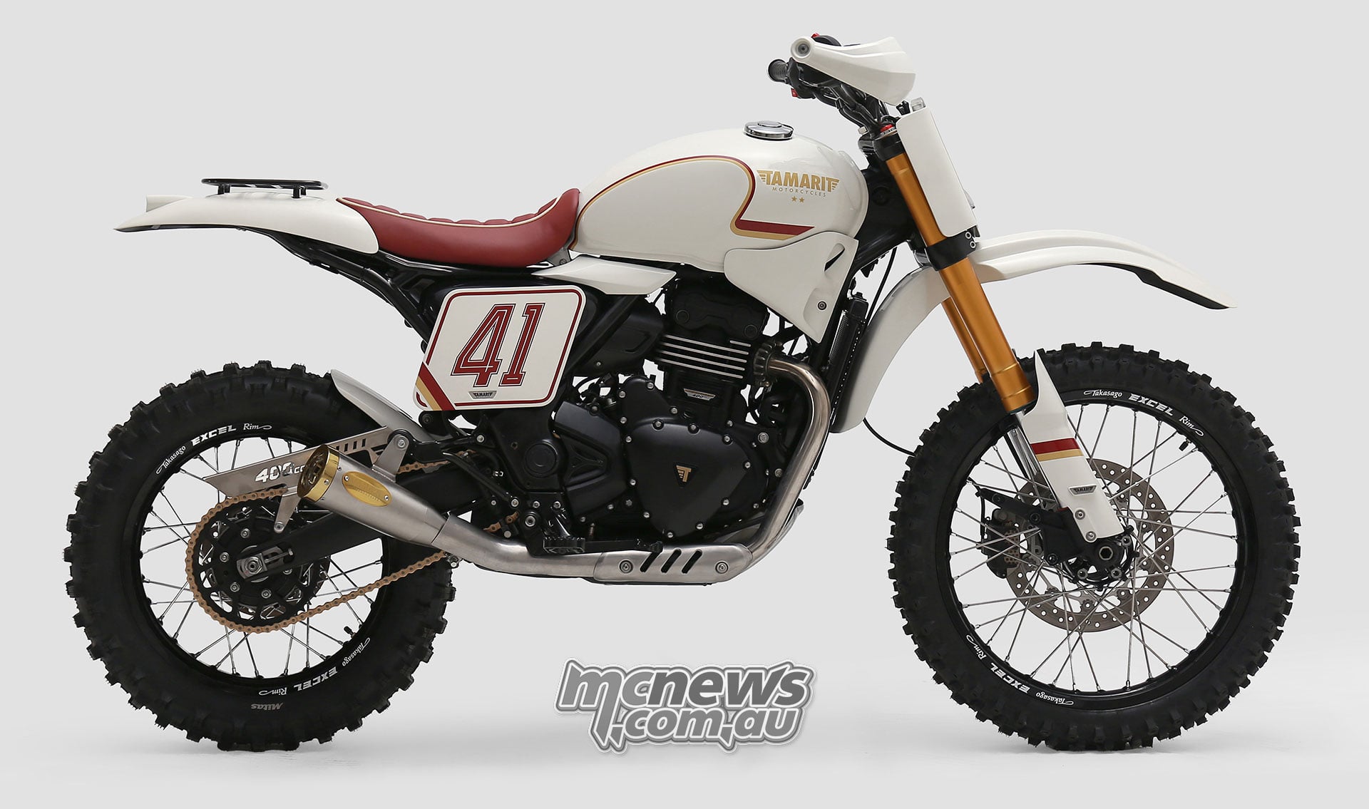 Cream Tamarit Triumph Scrambler 400 XC custom with a red seat, number 41 side panel, high mudguards and knobby tyres.