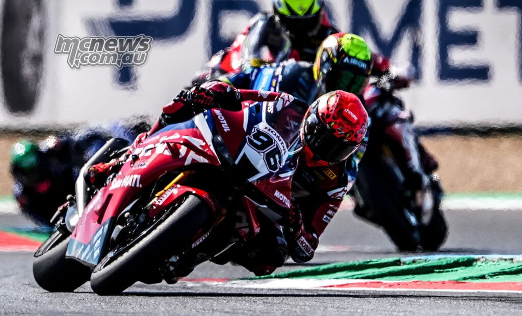 Jake Dixon leans the red, white and blue number 96 Honda Fireblade through a corner with two riders following.