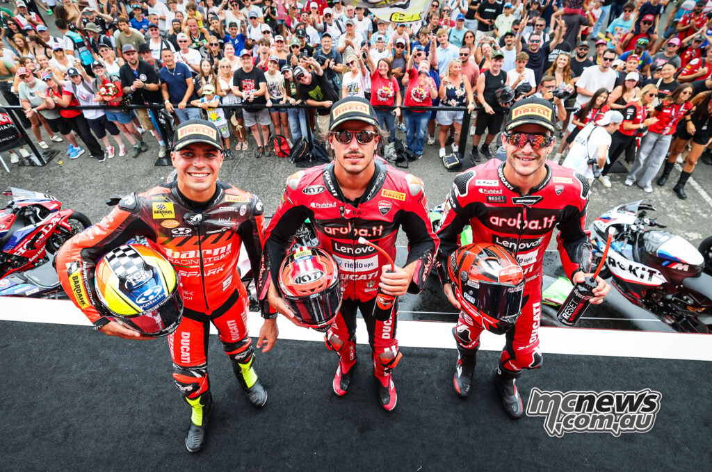 Yari Montella, Nicolo Bulega and Iker Lecuona pose in pit lane in front of the Magny-Cours crowd.