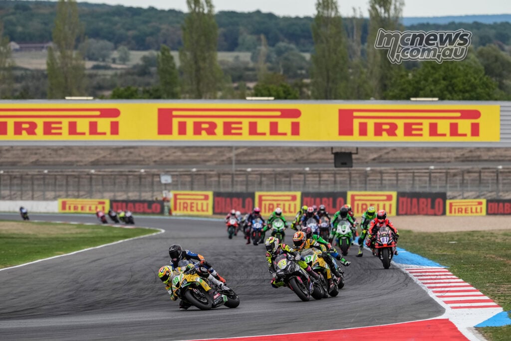 A large WorldSPB pack leans through a right-hand Magny-Cours corner beneath Pirelli signage.