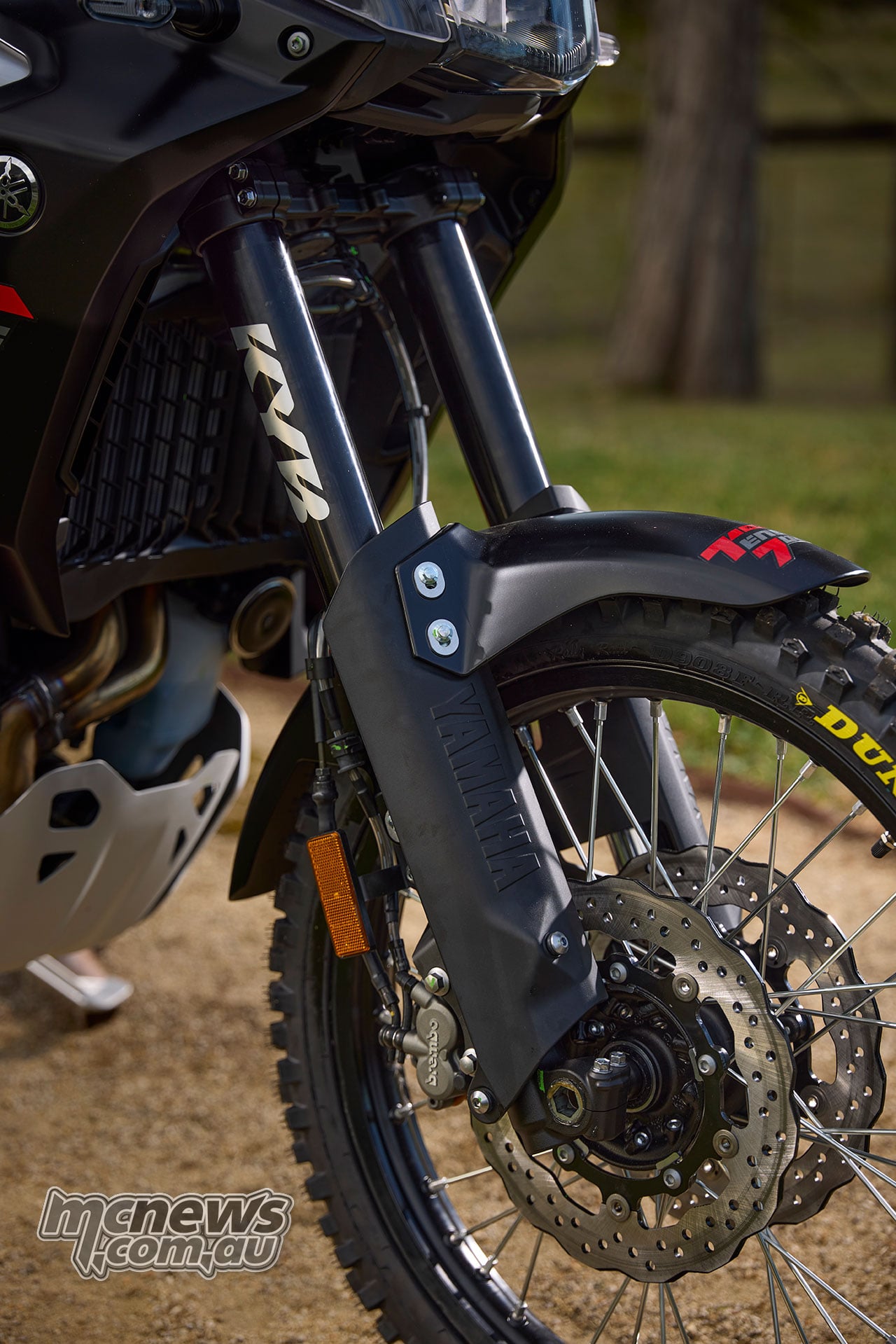 Close view of the World Raid’s KYB fork, spoked front wheel, brake disc and knobby front tyre.