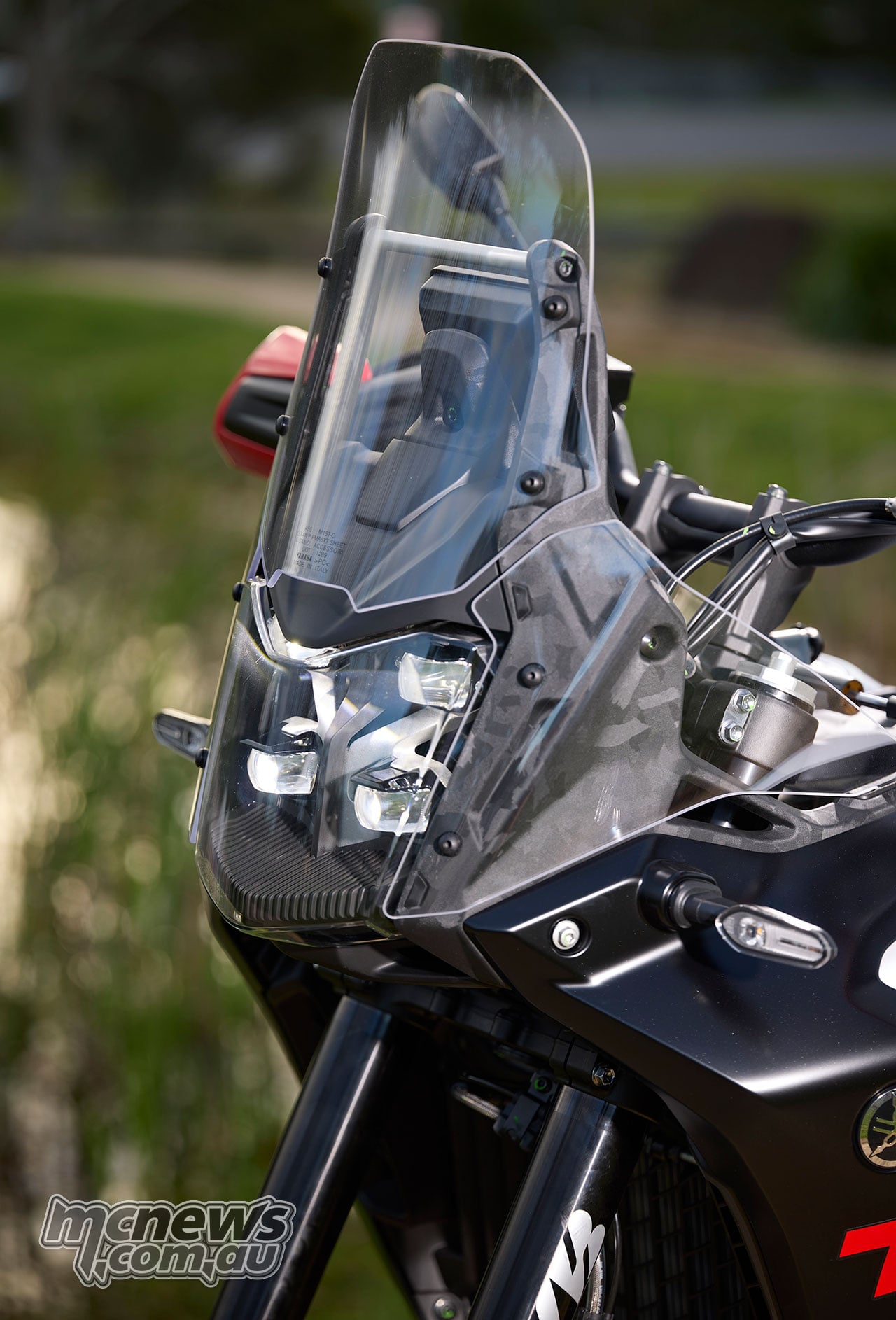 Close view of the World Raid’s tall clear windscreen and lower side deflectors above the headlight assembly.