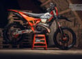 2027 KTM 300 EXC HARDENDURO in left-side profile on a stand inside a timber barn.