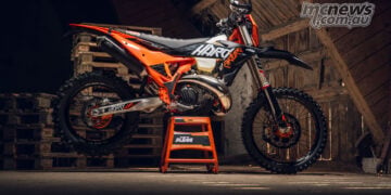 2027 KTM 300 EXC HARDENDURO in left-side profile on a stand inside a timber barn.
