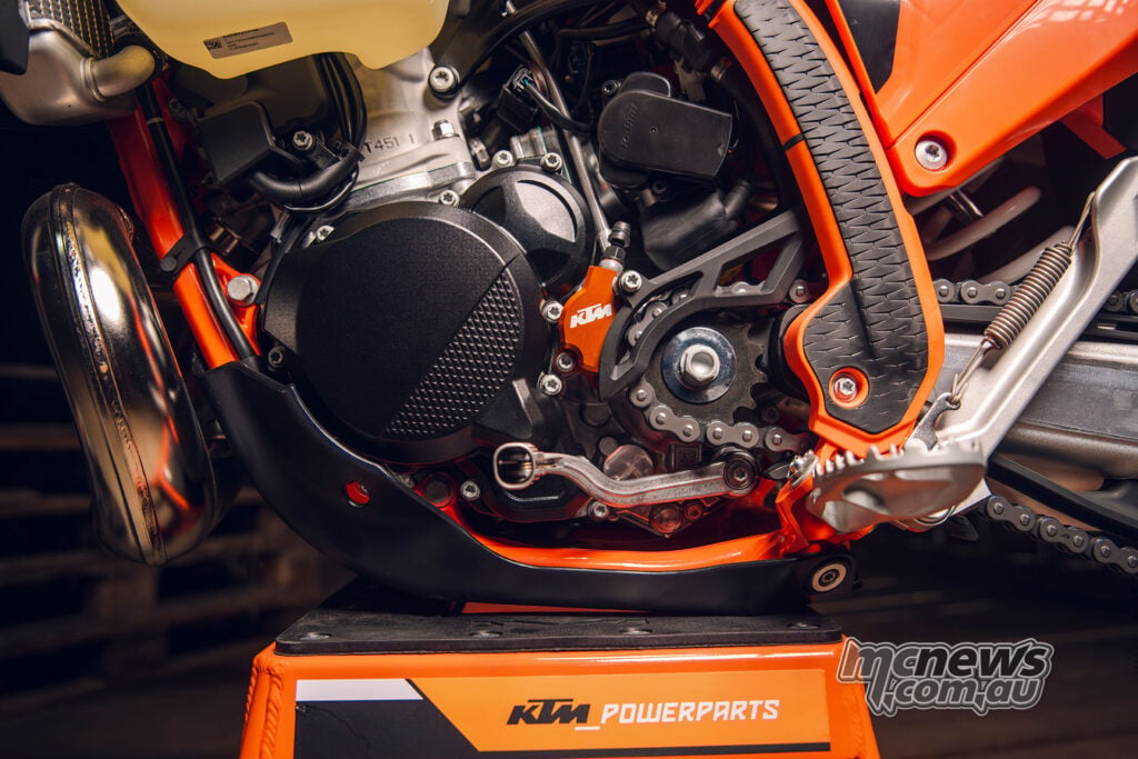 Engine detail showing clutch-slave protection, an orange frame guard and skid plate on the 2027 KTM 300 EXC HARDENDURO.