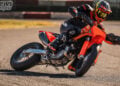 Rider leaning the orange 2027 KTM 450 SMR deeply into a paved Supermoto corner