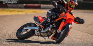 Rider leaning the orange 2027 KTM 450 SMR deeply into a paved Supermoto corner