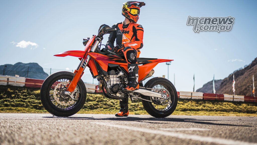 Rider stationary on the 2027 KTM 450 SMR at a Supermoto circuit beneath a clear sky
