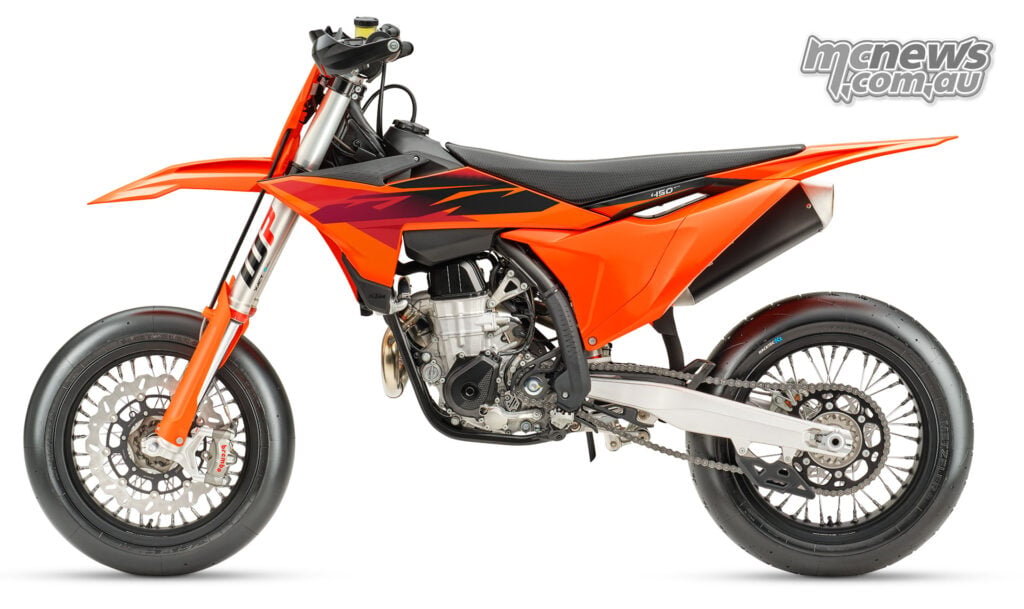 Left-side studio profile of the orange and black 2027 KTM 450 SMR Supermoto race bike