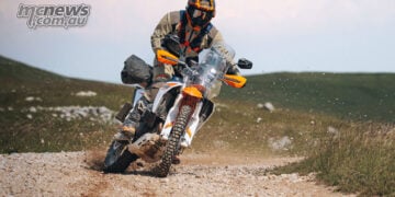 2027 KTM 690 Rally being ridden hard through a loose gravel corner