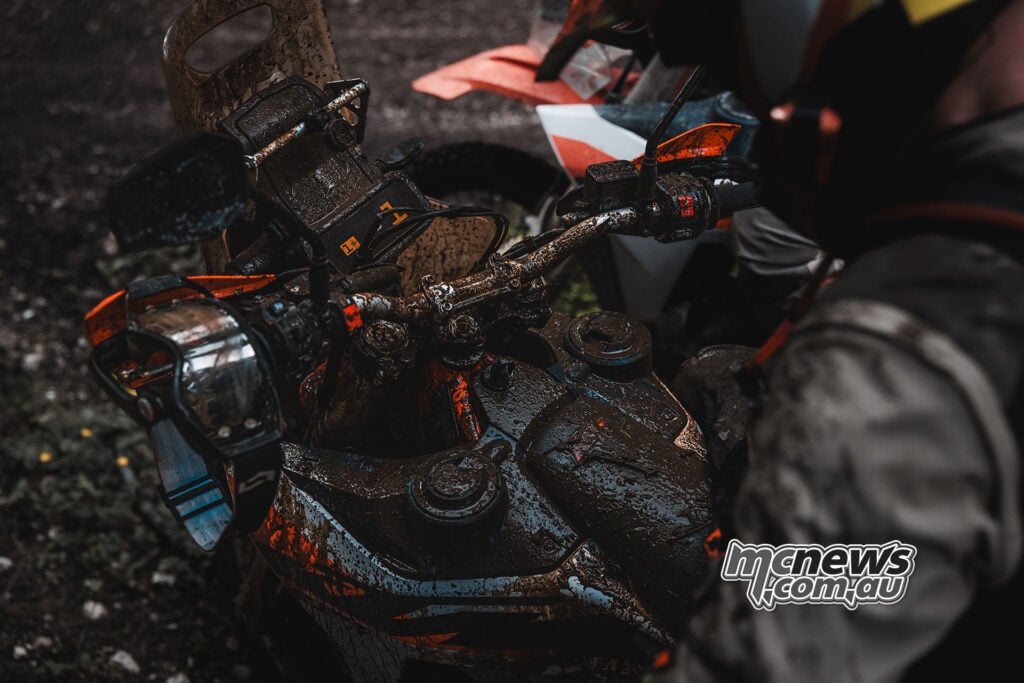 Mud-covered KTM 690 Rally cockpit and fuel tanks after off-road riding