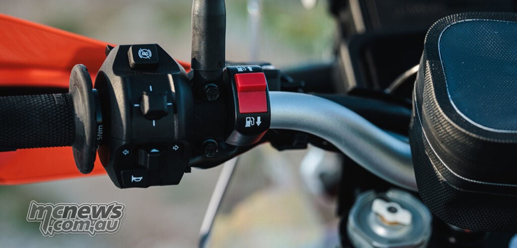 2027 KTM 690 Rally handlebar controls with red front and rear fuel tank selector switch
