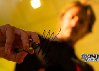 Nicolò Bulega signs a glass panel after being confirmed as a Pertamina Enduro VR46 MotoGP rider for 2027.