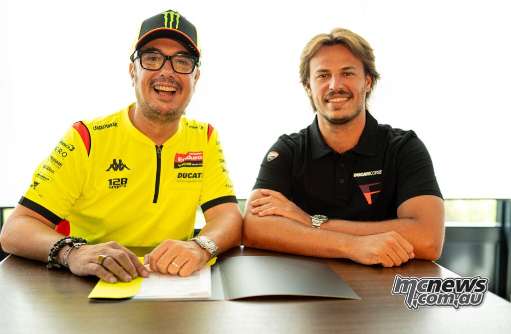 Alessio Salucci and Nicolò Bulega seated behind the agreement confirming Bulega’s move to VR46 for the 2027 MotoGP season.