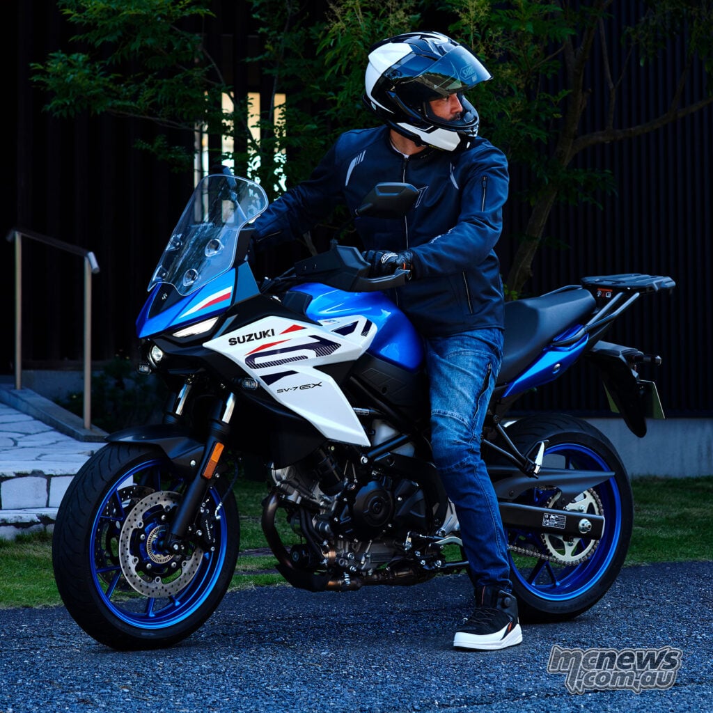 Rider sitting on a blue and white Suzuki SV-7GX with one foot flat on the ground