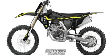 Left-side profile of the 2027 Triumph TF 250-X showing its drive chain, rear sprocket, aluminium frame and black bodywork.