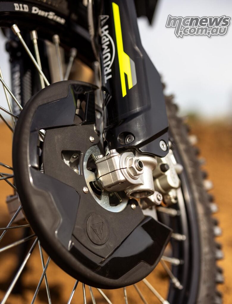 Close-up of the 2027 Triumph TF 250-X front brake disc protector, axle clamp and black fork guard with yellow graphics.