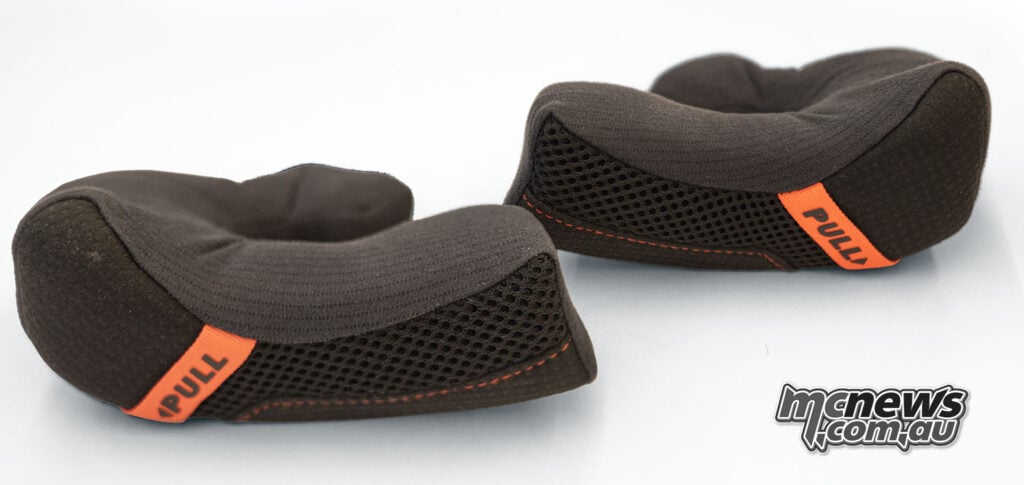 Pair of black Cardo Venture emergency-release cheek pads with orange pull tabs.