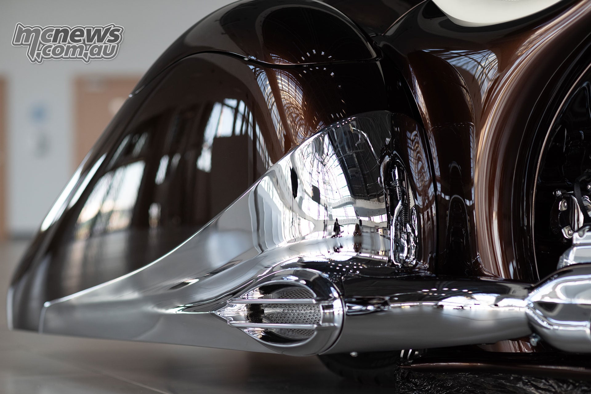 Sculpted chrome exhaust outlet beneath the bronze and chrome pannier on the Slow Burn custom motorcycle