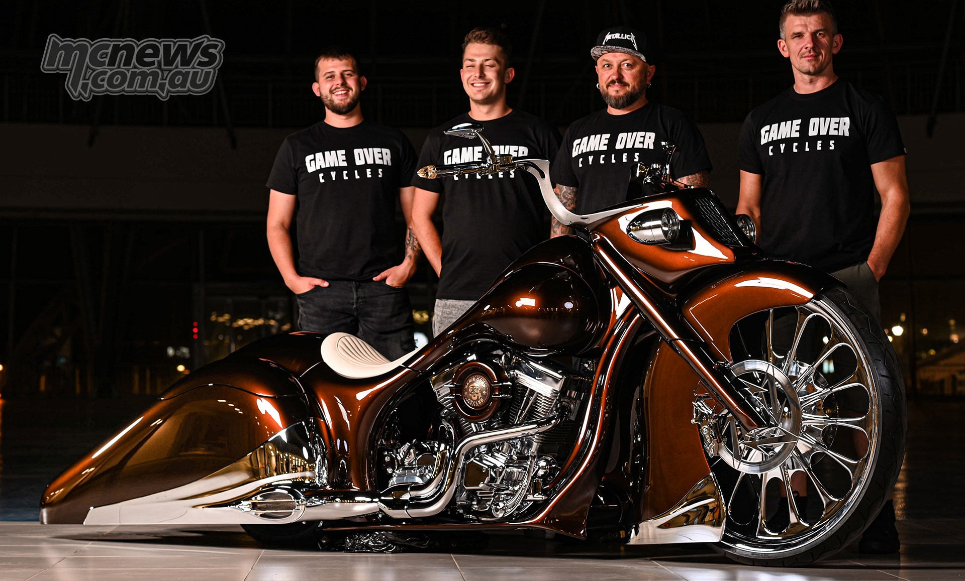 Four Game Over Cycles team members standing behind the completed Slow Burn custom motorcycle