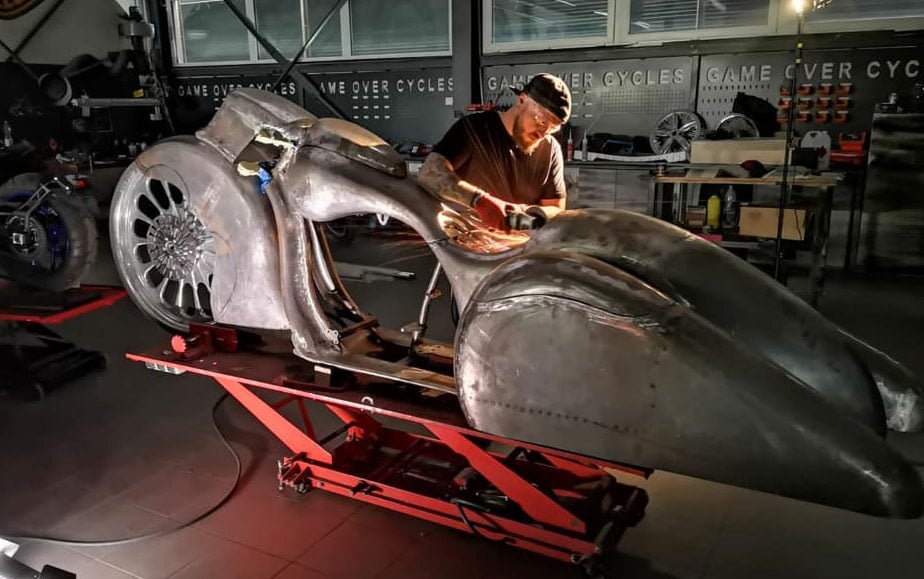 A fabricator working on Slow Burn’s bare metal bodywork in the Game Over Cycles workshop